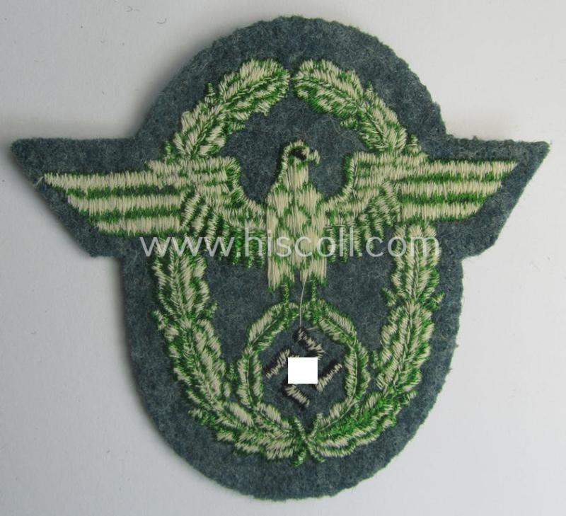 Clearly used- and/or tunic-removed, police- (ie. 'Polizei'- ie. 'Gendarmerie'-) related machine-embroidered-pattern arm-eagle, as executed in bright-green-coloured linnen on a typical 'Polizei'-coloured- and/or woolen-based, background