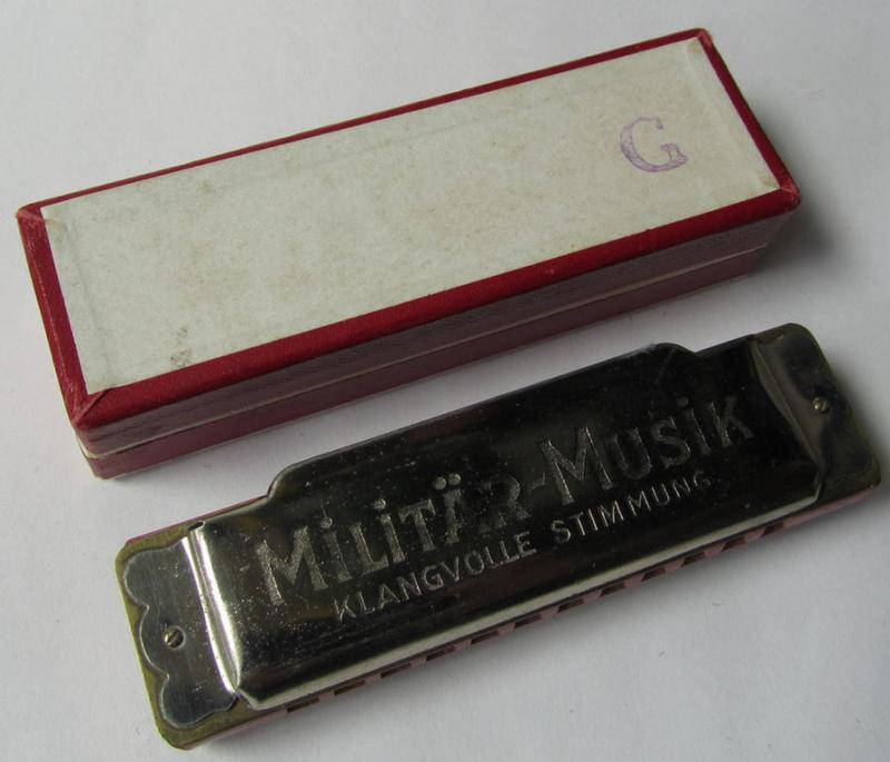 Attractive - and with certainty not that easily encountered! - TR-era- (ie. 'Deutsche Wehrmacht'-) related harmonica entitled: 'Militär-Musik' that came stored in its original, multi-coloured and/or carton-based box ie. etui