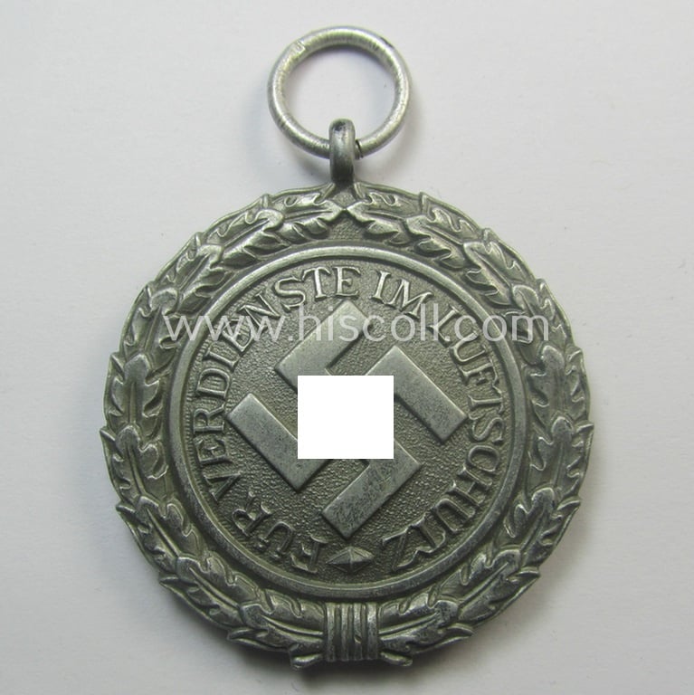 'Luftschutz-Ehrenzeichen 2. Stufe' being a maker- (ie. '10'-) marked example, as executed in (heavy) zinc-based metal (ie. 'Feinzink') and that came together with its period ribbon (ie. 'Bandabschnitt')