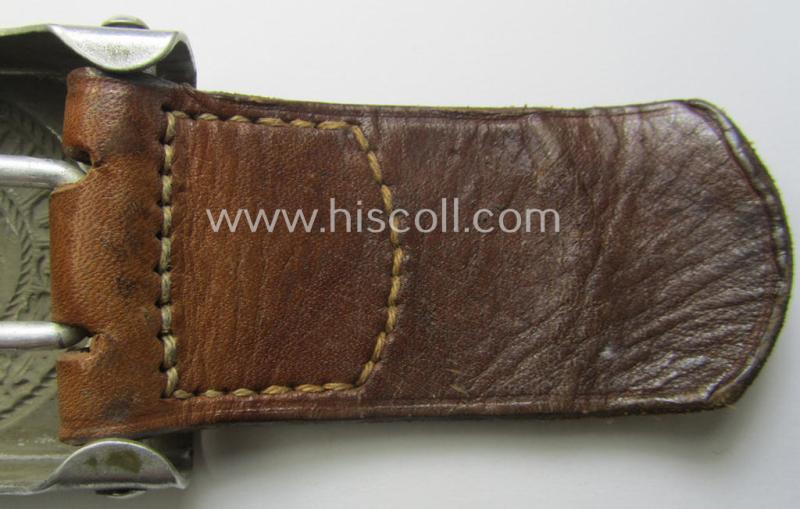WH (Heeres) 'standard-pattern', field-grey-toned- and aluminium-based belt-buckle being a maker- (ie. 'H. Arld - Nuernberg'-) marked- and/or: '1937'-dated example that comes mounted onto its leather-based tab