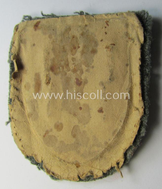 Attractive - just moderatey used and actually scarcely encountered! - WH (Heeres ie. Waffen-SS) 'Kuban'-campaign-shield that comes mounted onto its original field-grey-coloured- and/or woolen-based 'backing'