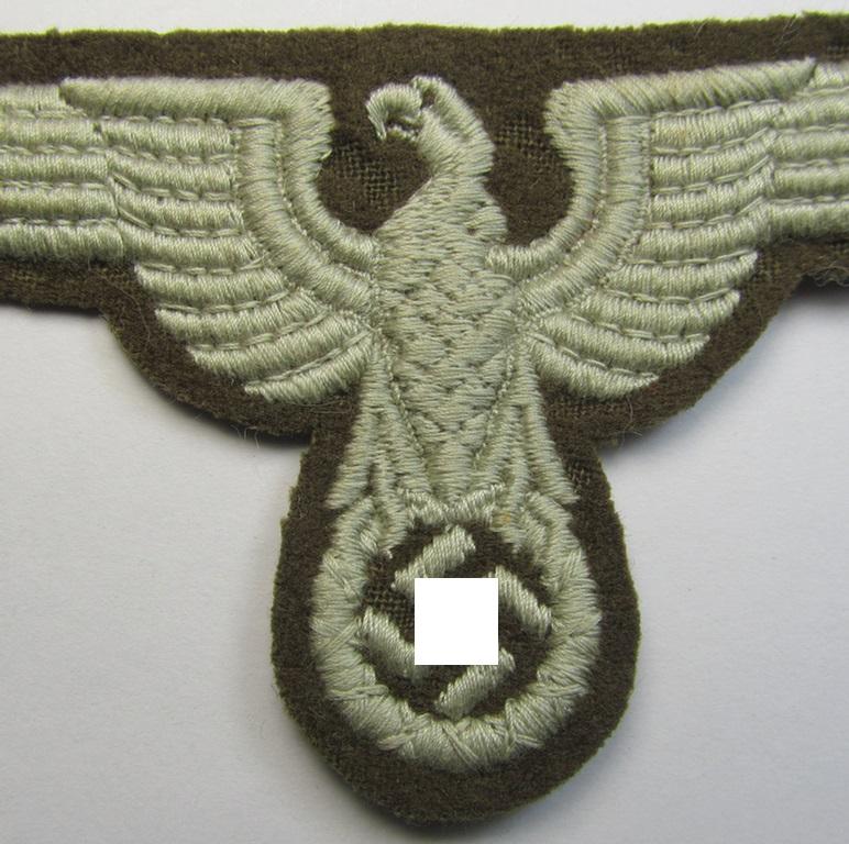 Attractive, machine-embroidered arm-eagle (ie. 'Ärmeladler') as was specifically intended for usage on the brownish-green-coloured tunics of officials of the: 'Reichsministerium für besetzte Ostgebiete' (ie. 'R.M.b.O.')