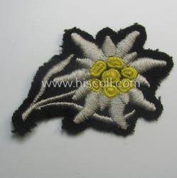 Waffen-SS-pattern, black-coloured M43-cap-insignia (ie. 'Mützenabzeichen') depicting an: 'Edelweiss'-flower...
