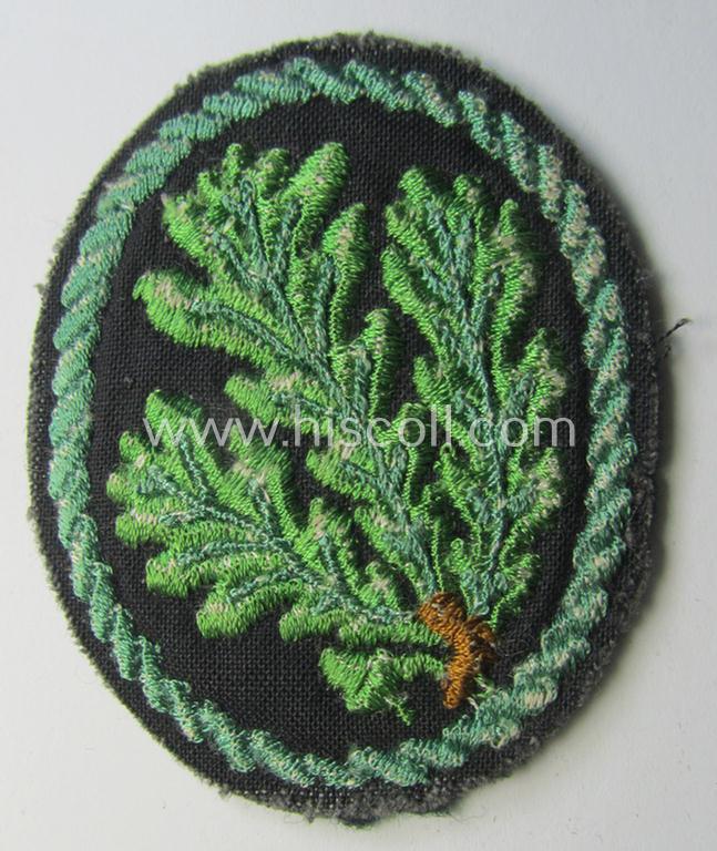 Attractive example of a WH (Heeres) so-called: 'Jäger'-armbadge being a neatly machine-embroidered- and/or multi-coloured version as was executed on darker-green-coloured wool
