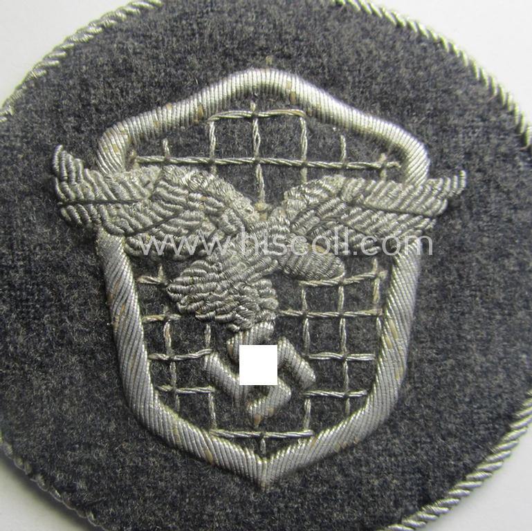 Superb - and actually rarely encountered! - example of a WH (Luftwaffe) neatly hand-embroidered, trade- ie. special-career-patch (ie. 'Tätigkeitsabzeichen') having a silverish-grey-toned 'Kordel' attached as was intended for: 'LW-Kraftfahrperson...