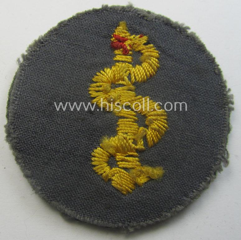 Clearly used- and/or tunic-removed WH (Heeres) so-called: trade- and/or special-career arm-insignia as was intended for a: 'Sanitäter' being a neatly hand-embroidered specimen on a field-grey-coloured background