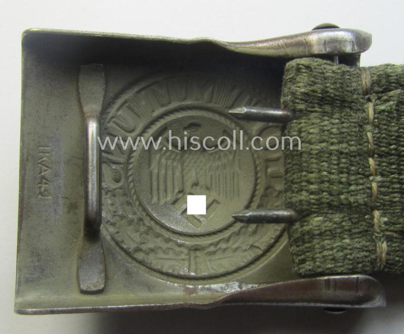 WH (Heeres) 'tropical-issued' belt-buckle being a clearly maker- (ie. 'IKA 41'-) marked, field-grey-coloured example that comes mounted onto its original, greenish-coloured- (and/or: 'webbing'-based-) tab