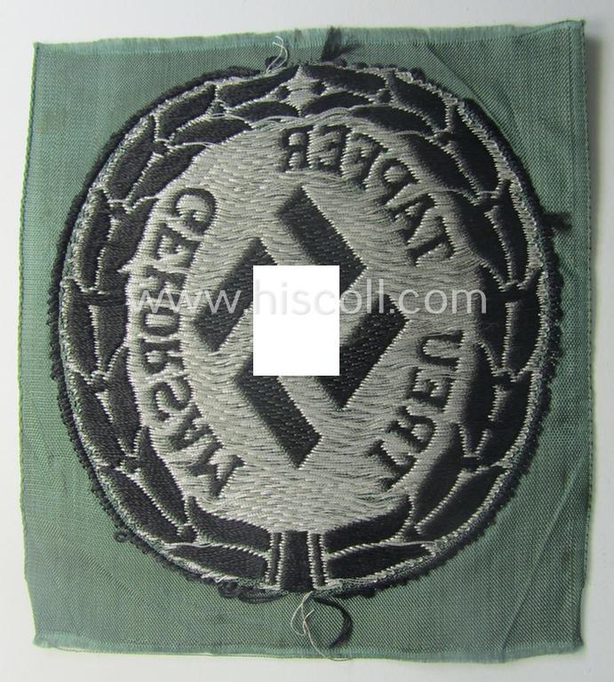 Officers'- (ie. evt. NCO-) type, so-called: 'Schutzmannschaften'- (ie. 'Schuma'-) armshield being executed in silver-grey-coloured 'flatwire'-type thread onto a field-grey-coloured background