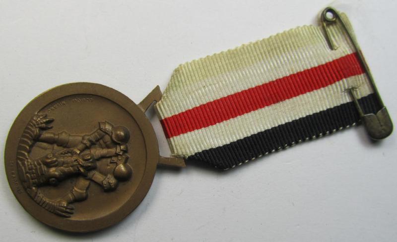 Superb, golden-bronze-coloured- (and I deem 'Buntmetall'-based-) example of a: 'Deutsch-Italienische Feldzugsmedaille' (or: German-Italian campaign medal) that comes mounted onto its (regular-sized) piece of original (albeit minimally faded) ribb...