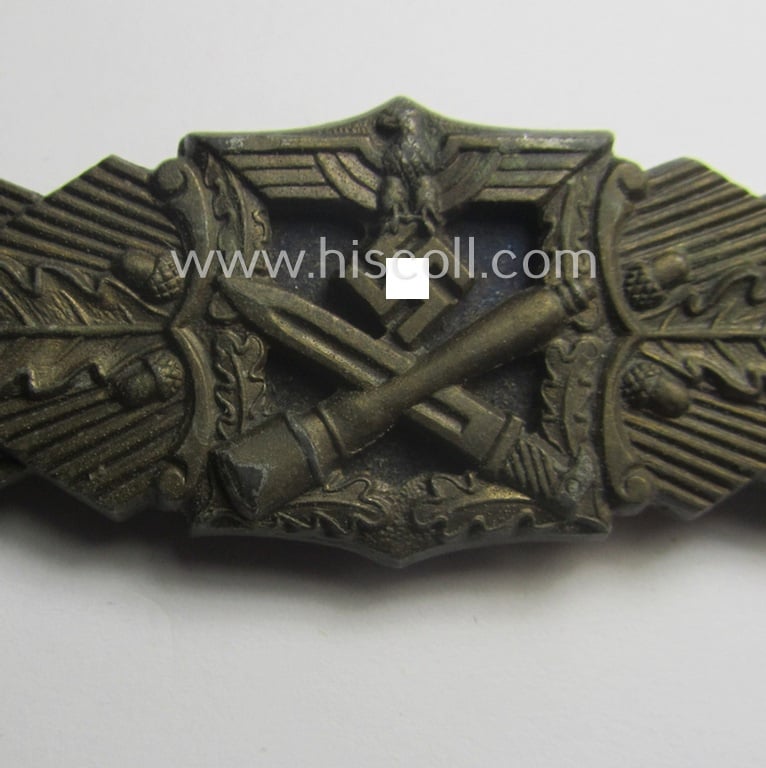 Superb, 'Nahkampfspange in Bronze' (or: bronze-class close-combat clasp ie. CCC) being a maker- (ie. 'A.G.M.u.K.'-) marked- and/or minimal converse-shaped specimen having its period-attached (black-toned and steel-based) 'back-plate' in place
