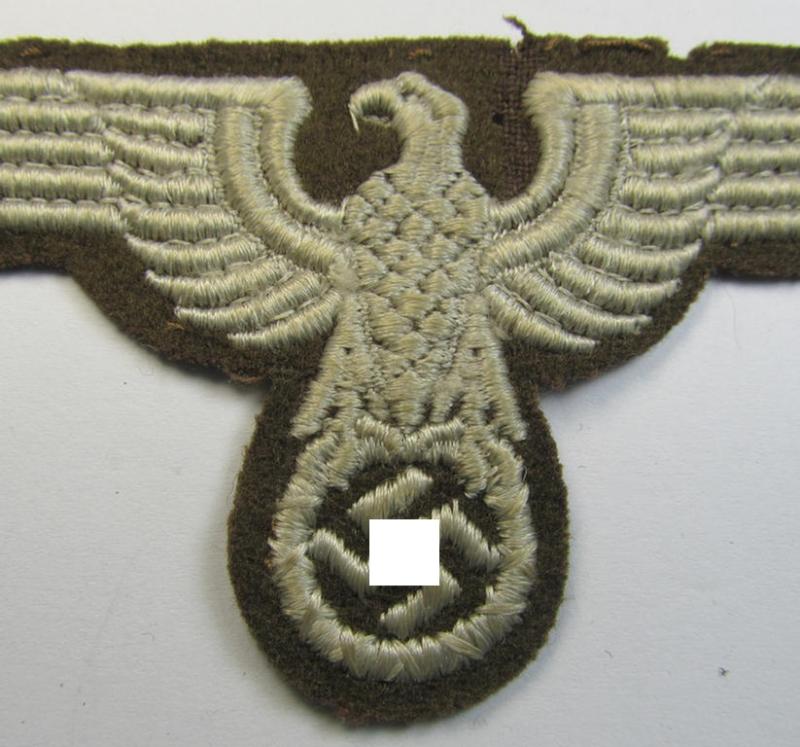 Attractive, machine-embroidered arm-eagle (ie. 'Ärmeladler') as was specifically intended for usage on the brownish-green-coloured tunics of officials of the: 'Reichsministerium für besetzte Ostgebiete' (ie. 'R.M.b.O.')