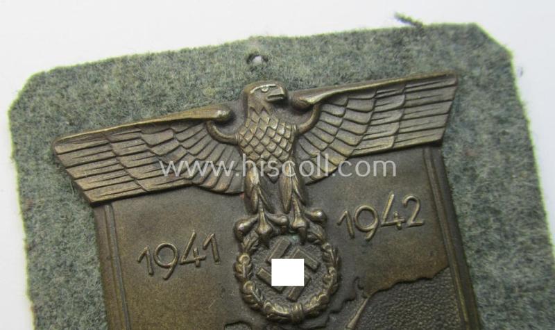 Attractive, WH (Heeres o. Waffen-SS) 'Krim'-campaign-shield that comes mounted onto its original, field-grey-coloured 'backing' and that comes in a surely issued-, minimally worn and/or (I deem) carefully tunic-removed-, condition