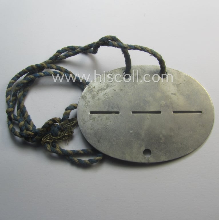 Aluminium-based, WH (Heeres) ie. 'Pionier-Truppen'-related ID-disc: '1./Pi.20' and that comes mounted onto its period cord as worn