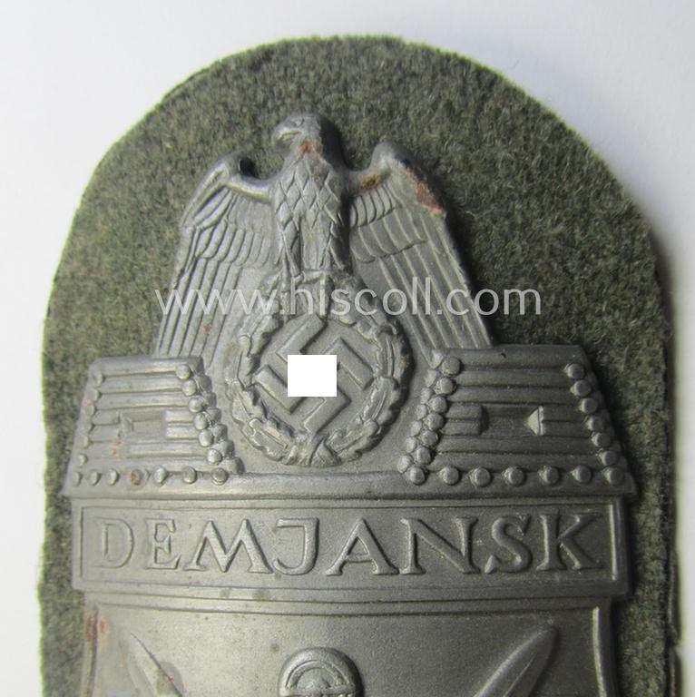 Superb, WH (Heeres ie. Waffen-SS) 'Demjansk'-campaign-shield as executed in typical magnetic metal (ie. so-called: 'Eisenblech') and that comes in an overall very nice- ie. fully untouched-, condition