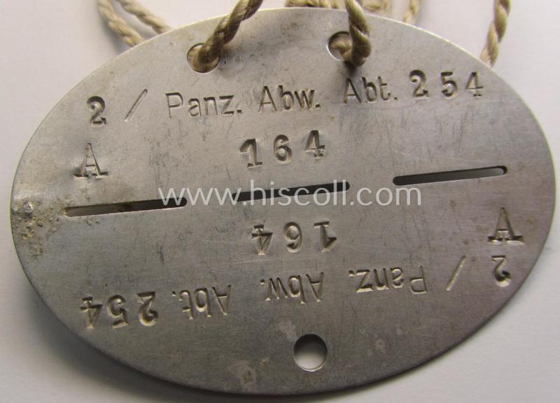 Aluminium-based, WH (Heeres) (ie. 'Pz-Abwehr'-related) ID-disc bearing the clearly stamped unit-designation that reads: '2 / Panz. Abw. Abt. 254' and that comes still mounted onto its (period-attached) cord