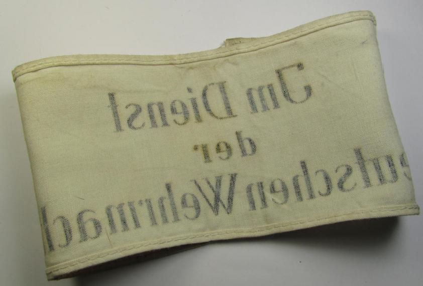 Linnen-based- and/or neatly 'printed', white-coloured armband (ie. 'Armbinde') entitled: 'Im Dienst der Deutschen Wehrmacht', as was intended for (civilian) staff-members of the German armed forces ie. 'Deutsche Wehrmacht'