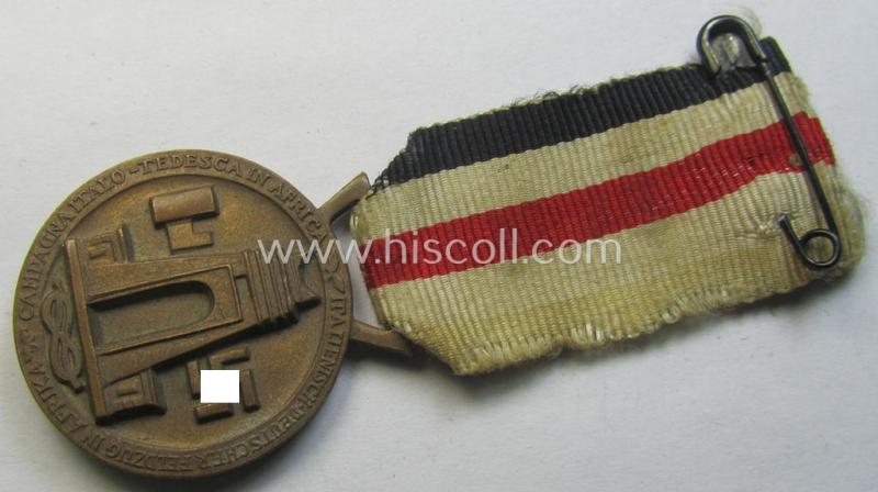 Attractive, golden-bronze-coloured- (and I deem 'Buntmetall'-based-) example of a: 'Deutsch-Italienische Feldzugsmedaille' (or: German-Italian campaign-medal) that comes mounted onto its (regular-sized) piece of original (albeit truly faded) ribb...