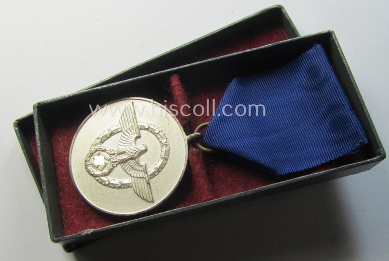 Bright-silver-toned so-called: 'Polizei-Dienstauszeichnung 3. Stufe' (or: police loyal-service medal 3rd class) that comes mounted onto its period ribbon (ie. 'Bandabschnitt') and that comes stored in its green-coloured etui