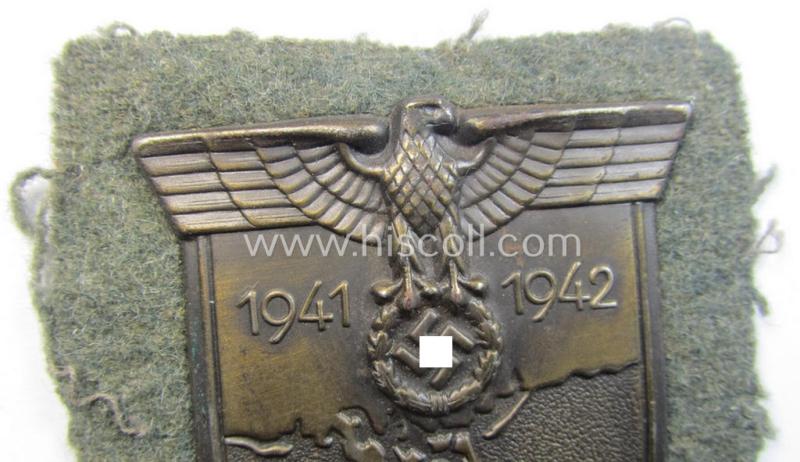 Attractive, WH (Heeres o. Waffen-SS) 'Krim'-campaign-shield that comes mounted onto its original, field-grey-coloured 'backing' and that comes in a surely issued-, minimally worn and/or (I deem) carefully tunic-removed-, condition