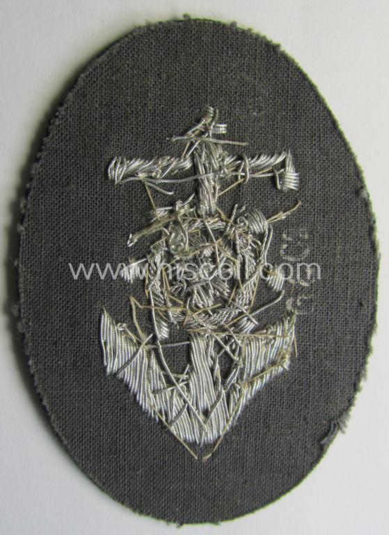 Superb, WH (Heeres) trade- and/or special-career insignia being a detailed- and/or neatly hand-embroidered example as executed on darker-green-coloured wool as was intended for a: 'Steuermann' (ie. enigineer-boat-pilot or helmsman)