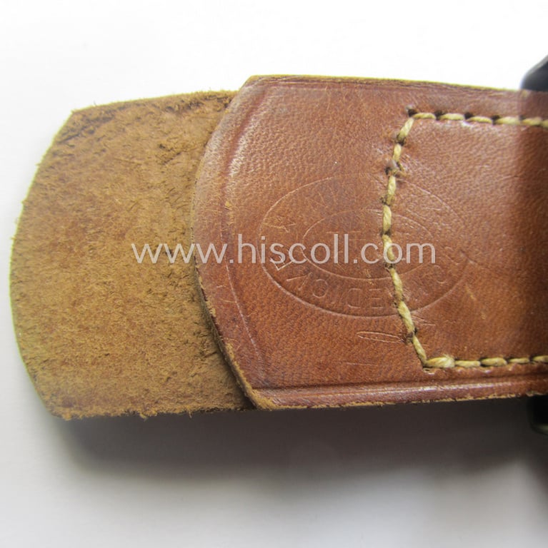 WH (Heeres) field-grey-coloured- and/or steel-based belt-buckle, being a maker- (ie. 'J. C. Maedicke'-) marked- and/or: '1941'-dated example that comes mounted on its leather-based tab and that comes in a moderately used- ie. worn, condition