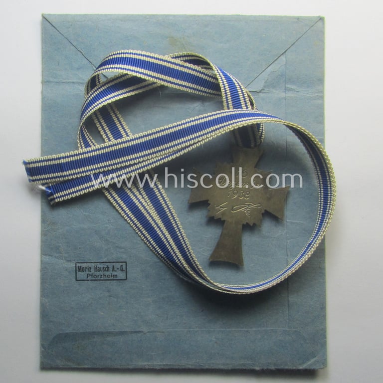 'Ehrenkreuz der deutschen Mutter - zweite Stufe' (or: silver-class mothers'-cross) that came mounted onto its long-sized ribbon and that came stored in its period pouch by the maker: 'Moriz Hausch A.-G. - Pforzheim'