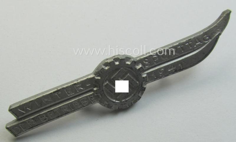 Silver-toned - and/or typical zinc-based - DAF- (ie. 'Deutsches Arbeitsfront'-) related day-badge depicting a pair of ski’s and a so-called: 'DAF-Zahnrad' and text: 'Wintersporttag der Betriebe 1941'