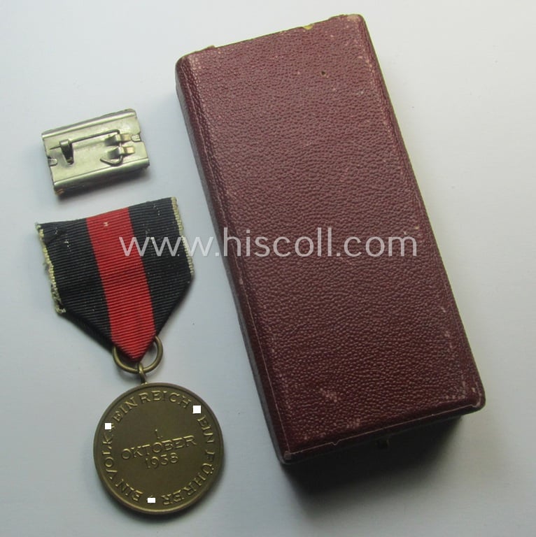 WH Czech-occupation- (ie. 'Anschluss'-) medal: '1. Oktober 1938' that comes with its period-attached 'PB-Spange' (and ribbon-bar) and that comes stored in its bordeaux-red-coloured- and/or non-maker-marked etui