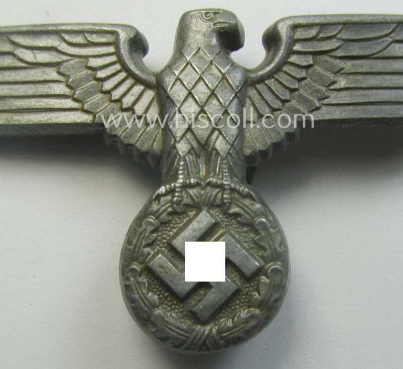 Greyish-silver-coloured- and/or: zinc- (ie. 'Feinzink'-) based (political-style) visor- (ie. 'Schirmmützen'-) cap-eagle being a detailed example that shows an: 'RzM M1/111'-makers'-designation on its back