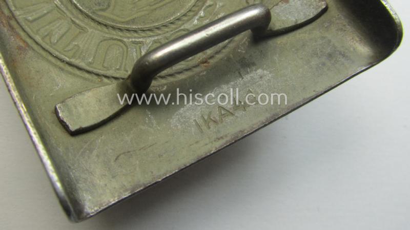 WH (Heeres) 'tropical-issued' belt-buckle being a clearly maker- (ie. 'IKA 41'-) marked, field-grey-coloured example that comes mounted onto its original, greenish-coloured- (and/or: 'webbing'-based-) tab
