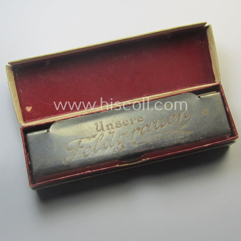 Neat, typical TR-era- (ie. 'Deutsche Wehrmacht'-) related harmonica entitled: 'Unsere Feldgrauen' that came stored in its original and/or carton-based box ie. etui