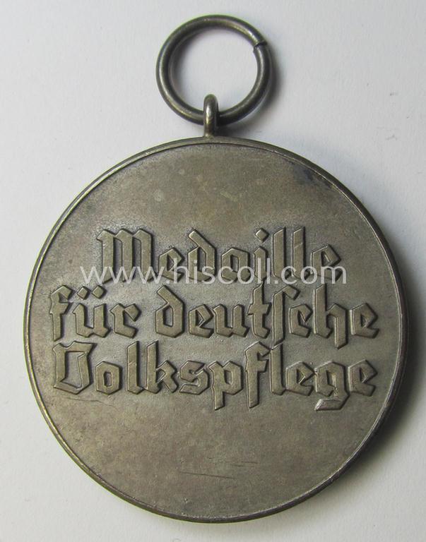 Attractive, silver-toned (and I deem zinc- ie. 'Feinzink'-based!) 'Deutsche Volkspflege'- (ie. civil-service) medal being a non-maker-marked example that came together with its (confectioned- and somewhat shortened) ribbon (ie. 'Bandabschnitt')