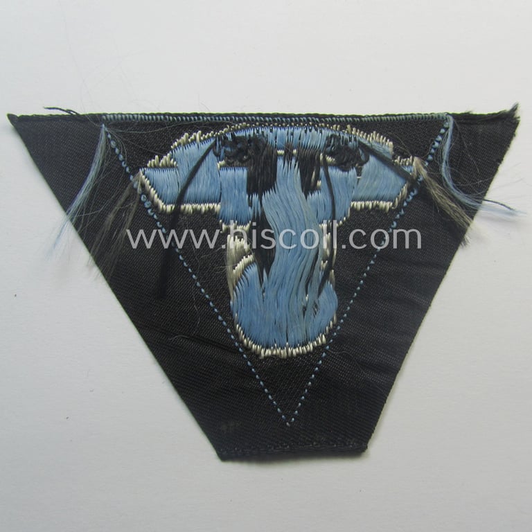 'Virtually mint' so-called: N.S.K.K. (ie. 'National Socialistisches Kraftfahr Korps') side-cap-eagle (ie. 'Adler für Schiffchenmütze') being a 'BeVo-woven'-example that comes mounted onto a light-blue-coloured background