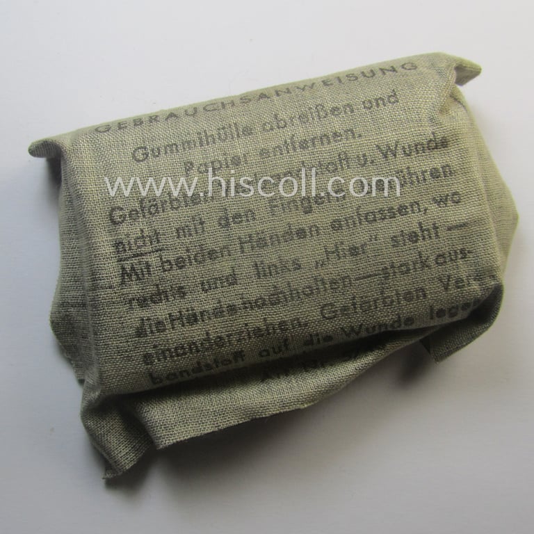 WH (Heeres, Luftwaffe etc.) greyish-beige-coloured- and/or rubberised-linnen-based bandage-package (or: 'Verbandpäckchen') dated: '1944' that comes in a never used- (ie. 'virtually mint- ie. unissued'-), condition