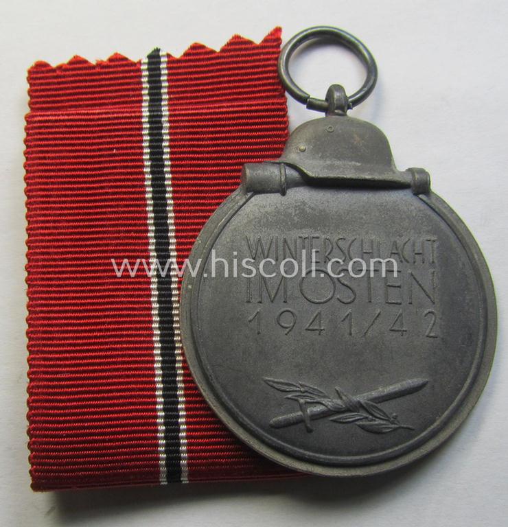 Attractive medal-set: 'Winterschlacht im Osten 1941-42' being a maker- (ie. '61'-) marked- (and/or 'Feinzink'-based) specimen by the maker: 'R.A. Karneth & Söhne' and that comes together with its (non-confectioned) ribbon (ie. 'Bandabschnitt...