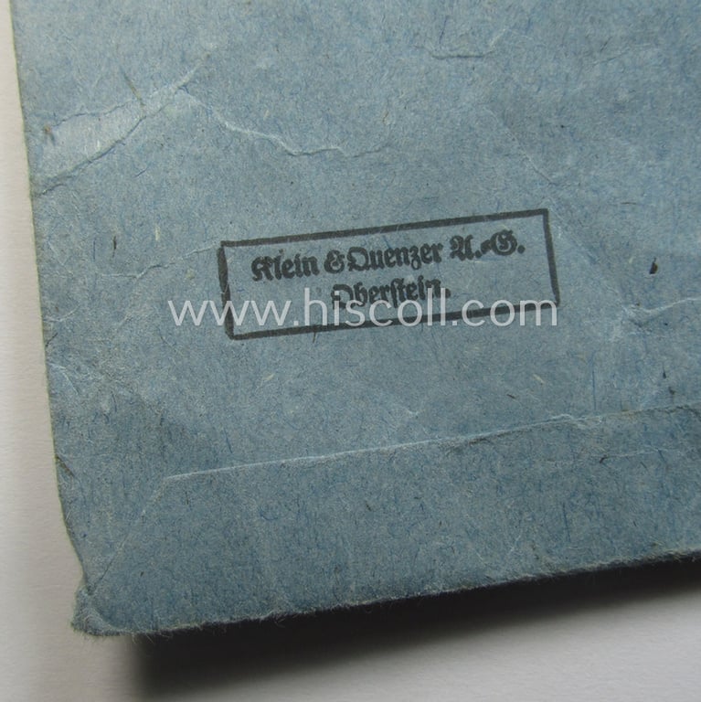 'Eisernes Kreuz 2. Kl.' (ie. Iron Cross 2nd Class) being a maker- (ie. '65'-) marked example that comes stored in its period 'Zellstoff'-based pouch by the: 'Klein & Quenzer'-company