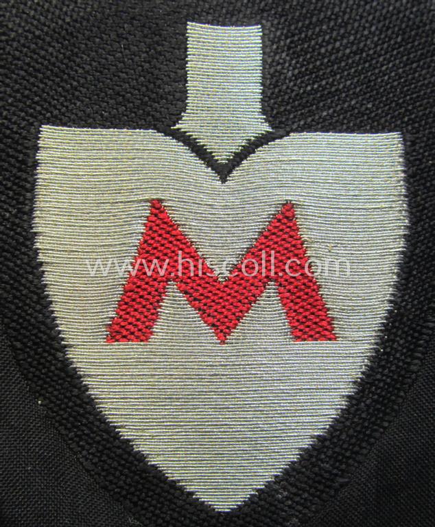 Attractive - and actually very scarcely encountered! - officers'-pattern, so-called: RAD (ie. 'Reichsarbeitsdienst') sleeve-badge (or: 'Dienststellenabzeichen') bearing the specialist-designation: 'M' (or: 'Hauptmeldebeambter')