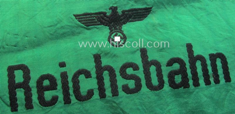DRB- (ie. 'Deutsche Reichsbahn'-) related armband entitled: 'Reichsbahn' being of the 'entirely-woven'-type onto (typical) silk-like cloth in a technique similar to the 'BeVo'-weave pattern
