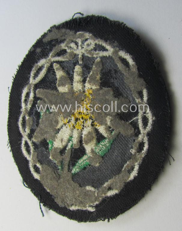 Truly used and/or tunic-removed, WH (Heeres) EM- (ie. NCO-) type, so-called: 'Edelweiss'-armpatch being a machine-embroidered example as was executed on darker-green wool as was specifically intended for usage by the: 'Gebirgsjäger-Truppen'