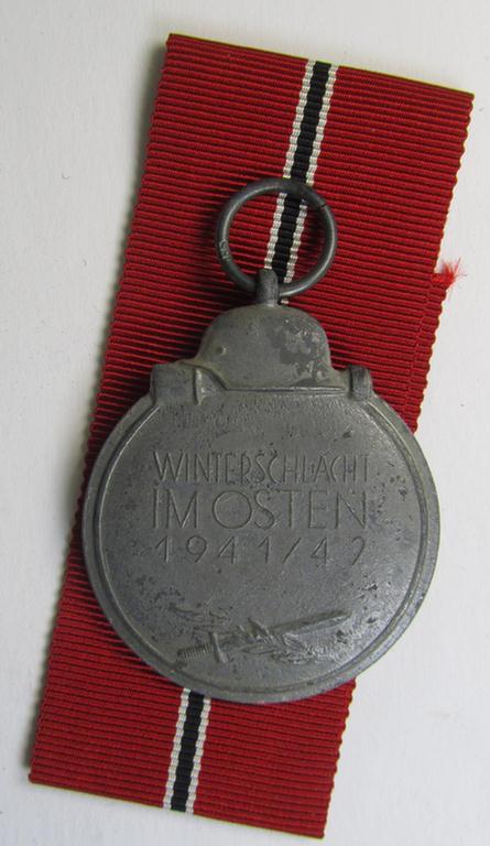 Medal-set: 'Winterschlacht im Osten 1941-42' being a clearly maker- (ie. '55'-) marked- (and/or 'Feinzink'-based) specimen by the maker: 'J.E. Hammer & Söhne' and that comes together with its (non-confectioned) ribbon (ie. 'Bandabschnitt')