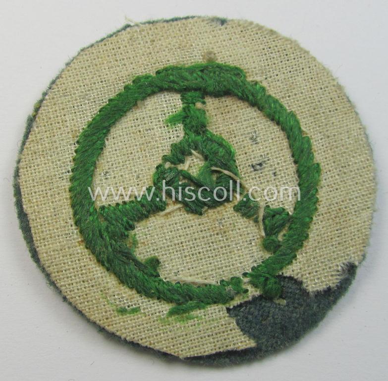 Police- (ie. 'Schutzpolizei'-) related, neatly hand-embroidered, trade- ie. special-career patch (ie. 'Laufbahn- o. Tätigkeitsabzeichen') depicting a bright-green-coloured steering-wheel as was intended for: 'Kraftfahrpersonal'