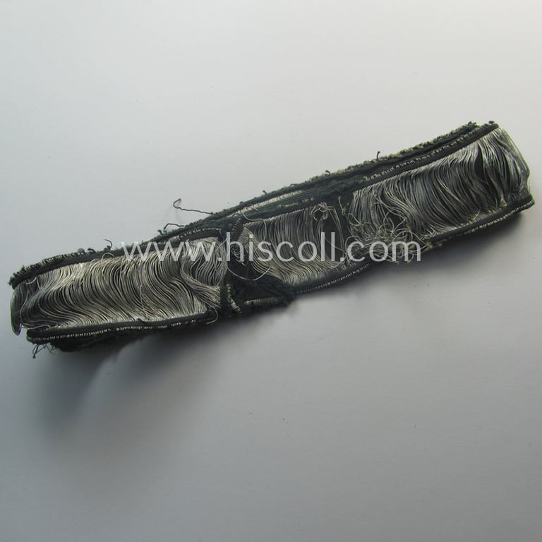 Truly worn- (ie. relic) example of the - rarely encountered! - WH (Heeres) EM- (ie. NCO-) type 'Grossdeutschland'-cuff-title (ie. Ärmelstreifen) being a shortened example of the 1st pattern (as executed in so-called: 'BeVo-flat-wire-woven'-pattern)