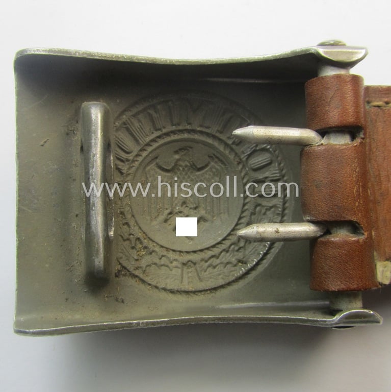 WH (Heeres) 'standard-pattern', field-grey-toned- and aluminium-based belt-buckle being a maker- (ie. 'E. Schneider - Lüdenscheid'-) marked- and/or: '1938'-dated example that comes mounted onto its leather-based tab