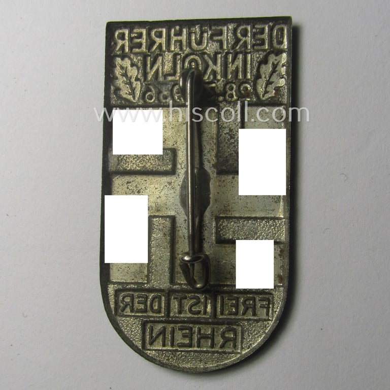 Greenish-coloured- and/or tin-based, N.S.D.A.P.-related day-badge (ie. 'tinnie' or: 'Veranstaltungsabzeichen') being a commemorative example that is entitled: 'Der Führer in Köln - 28.3.1935' and sub-titled: 'Frei ist der Rhein!'