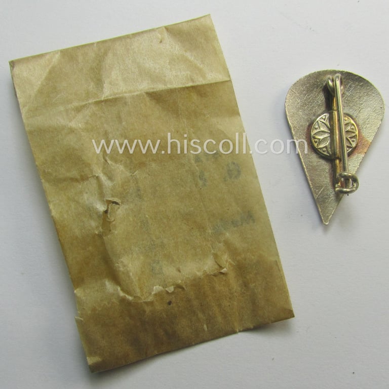 Neatly enamelled, WH (Luftwaffe) so-called: 'Truppen-Traditionsabzeichen des 1. Fallschirm-Korps' that comes stored in its period, 'Cellophan'-based pouch by the (Italian) maker: 'G. Bregonzio - Milano'
