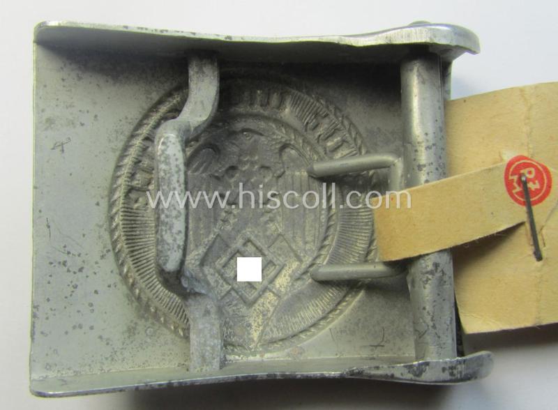 HJ ('Hitlerjugend'), zinc-based belt-buckle being a 'virtually mint' and/or non-maker-marked example having a seldomly seen 'cranked-catch'-set-up and that comes with its period 'RzM'-etiket still attached