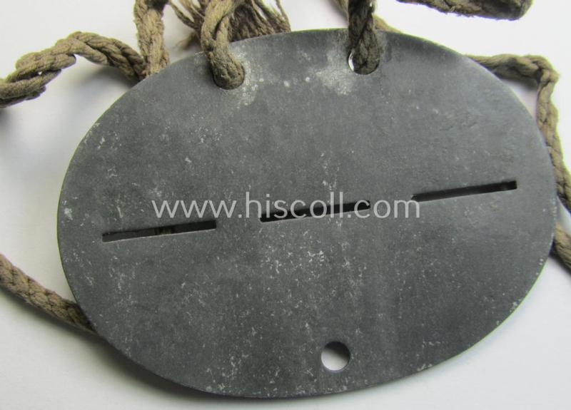 Zinc-based, WH (Heeres) ie. 'schwere Artillerie'-related ID-disc bearing the clearly stamped unit-designation: 'Stamm-Battr.s.Art.Ers.Abt.(mot) 105' and that comes mounted onto its period cord as issued and worn