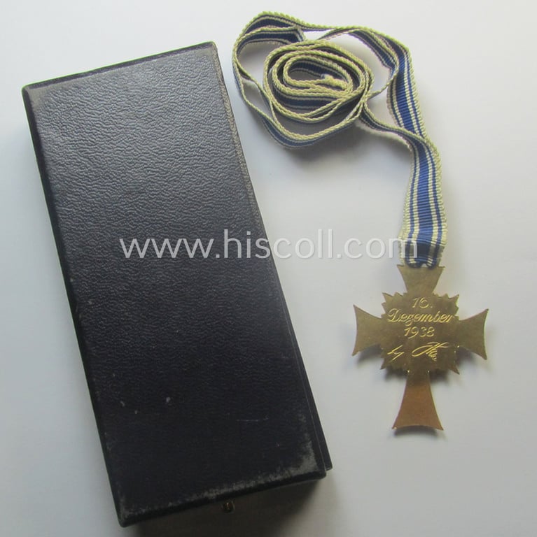 By 'C.E. Juncker-produced 'Ehrenkreuz der deutschen Mutter - erste Stufe' (or mothers'-cross in gold) that comes stored in its original and/or neatly maker- (ie. 'C.E. Juncker - Berlin'-) marked etui