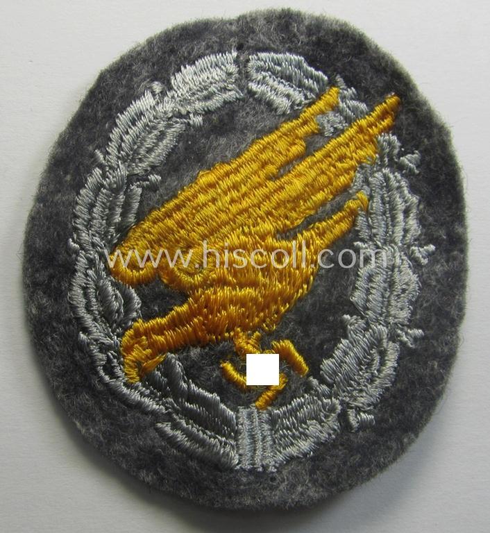WH (Luftwaffe) 'Fallschirmschützen-Abzeichen in Stoff' (or: cloth-based paratroopers'-jump-badge) being nicely machine-embroidered specimen that come in a never used- ie. 'virtually mint-/unissued', condition