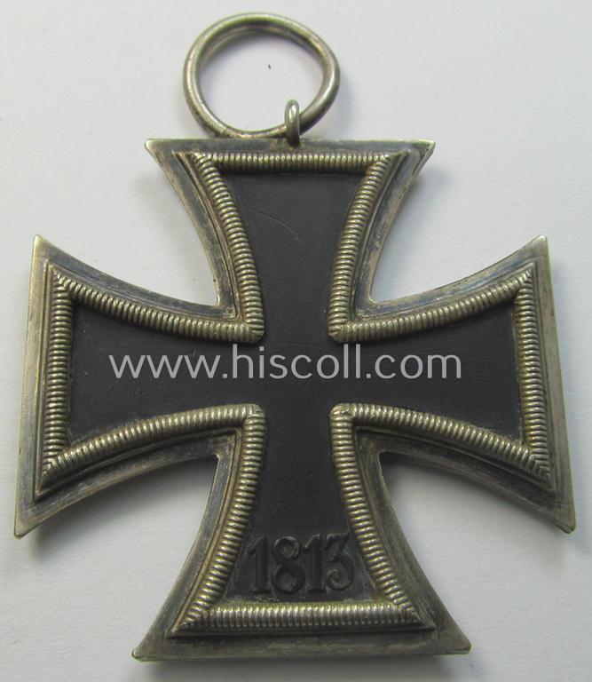 Moderately used, 'Eisernes Kreuz II. Klasse' being a non-maker-marked example that comes together with its original- and once-mounted ribbon (ie. 'Bandabschnitt') as was produced by a (by me) unidentified maker (ie. 'Hersteller')